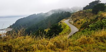 Road going uphill leading to a foggy mountain