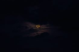 Moon hiding behind clouds and creating beautiful patterns on the dark clouds