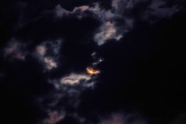 Moon hiding behind clouds and creating beautiful patterns on the dark clouds