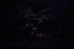 Moon hiding behind clouds and creating beautiful patterns on the dark clouds