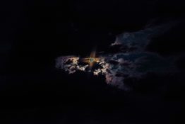 Moon hiding behind clouds and creating beautiful patterns on the dark clouds