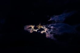 Moon hiding behind clouds and creating beautiful patterns on the dark clouds