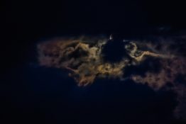 Moon hiding behind clouds and creating beautiful patterns on the dark clouds