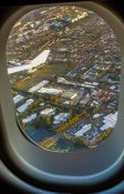 Looking at buildings and homes from a planes window as it circles over a residential area