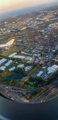 Looking at buildings and homes from a planes window as it circles over a residential area