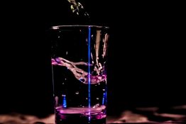 Different light and colours used to add colorful effects to glass of water