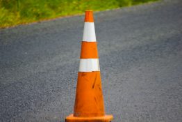 Orange and white traffic cone placed on a road